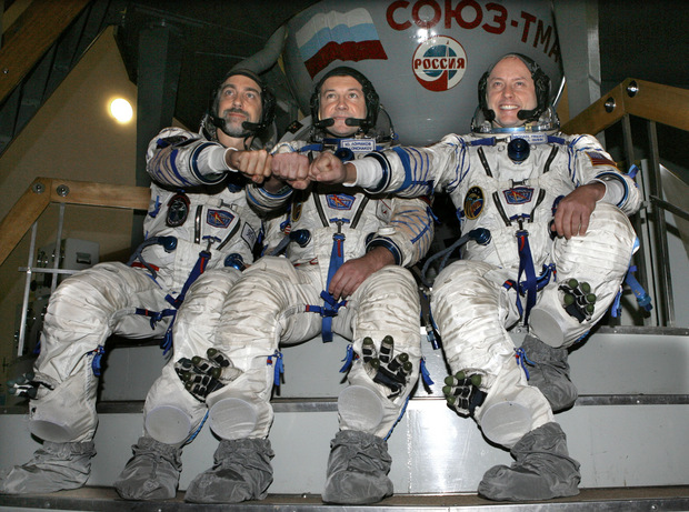 Zľava doprava americký vesmírny turista Richard Garriott, ruský kozmonaut Jurij Lončakov a americký astronaut Michael Fincke pred záverečným testom v modeli vesmírnej rakety Sojuz TMA v Hviezdnom mestečku pri Moskve 19.septembra 2008.